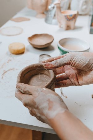 Photo for Close up of female hands making a mug from clay in a workshop. Selective focus. - Royalty Free Image