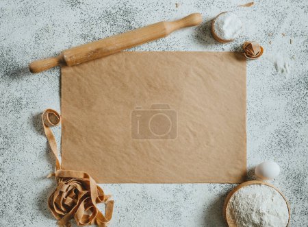 Photo for Paper with copy space near handmade pasta, rolling pin, flour and eggs. Top view, flat lay. - Royalty Free Image