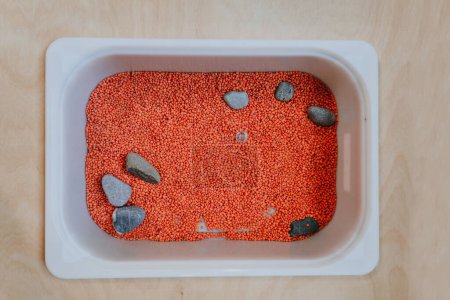 Plastic containers for toys with lentils for developing tactility in children in kindergarten. Top view.