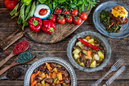 Foto de Meat stew with vegetables. Orman kebabi . Cooked foods in the copper plate or pot. - Imagen libre de derechos