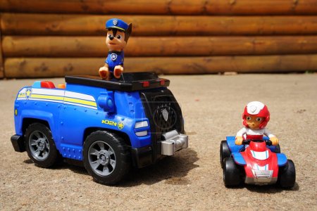 Photo for New Lisbon, Wisconsin USA - May 10th, 2023: Paw Patrol Police pup Chase and Ryder kids action figure toys sit outside on a sunny day. - Royalty Free Image