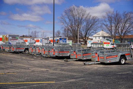 Téléchargez les photos : Baraboo, Wisconsin États-Unis - 19 avril 2022 : Remorques et camions U-Haul stationnés et entreposés sur un parking prêt à l'emploi. - en image libre de droit