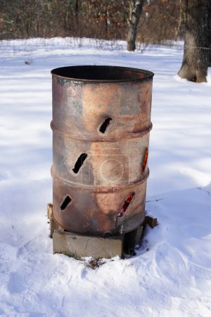 Photo for Burning trash barrel sits outside during the cold winter. - Royalty Free Image