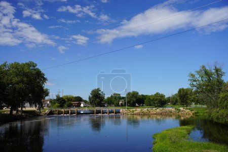 Photo for River flow dam in New Lisbon, Wisconsin reflects off the water during the morning. - Royalty Free Image
