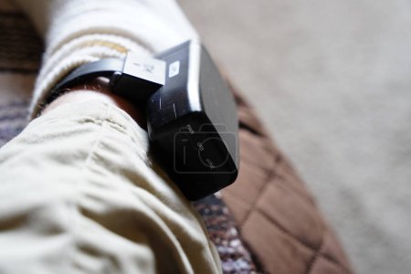 Téléchargez les photos : Bracelet de surveillance GPS prison assignation à résidence sur la cheville masculine en raison de la peine de prison. - en image libre de droit