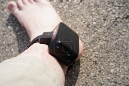 House arrest GPS jail monitoring bracelet on male ankle due to jail sentence.