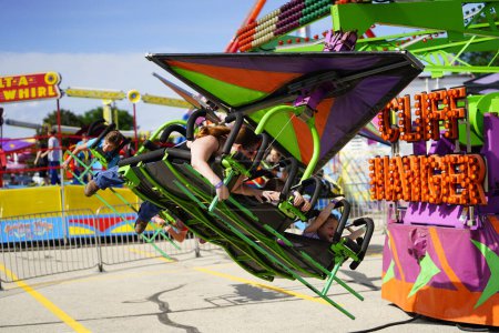 Photo for Fond du Lac, Wisconsin / USA - July 21st, 2019: Many kids, teenagers and family members having enjoyment on Cliff Hanger thrill ride at Fond du Lac County Fair. - Royalty Free Image