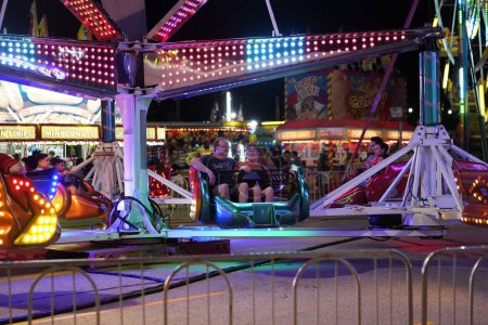 Photo for Fond du Lac, Wisconsin / USA - July 17th, 2019: Many adults and kids from the Fond du Lac, Wisconsin area came out to ride on the Scrambler fair ride during the night at Fond du Lac's County fair. - Royalty Free Image