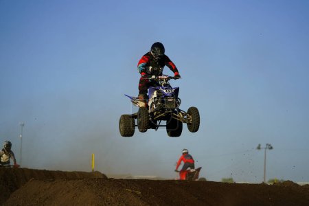 Foto de ATV quad motos corrió y realizó acrobacias durante un evento de carreras de automovilismo supercross en una pista de tierra. - Imagen libre de derechos