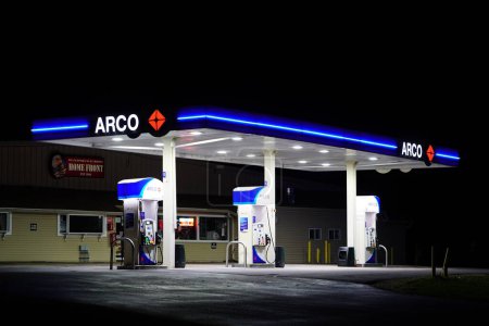 Foto de Camp Douglas, Wisconsin - 15 de abril de 2022: La estación de servicio de Arco ilumina la noche. - Imagen libre de derechos
