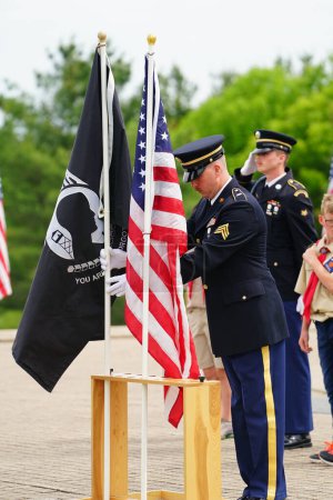 Foto de Neillsville, Wisconsin - 29 de mayo de 2023: Niños y niñas exploradores caminaron con soldados de la Guardia Nacional para saludar la bandera estadounidense. - Imagen libre de derechos