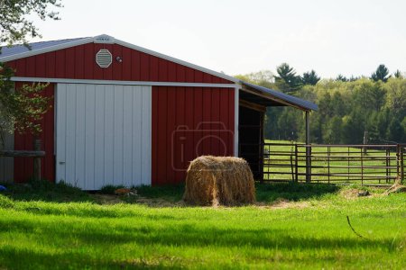 Téléchargez les photos : Un plan vertical d'une grange dans une zone rurale avec une ferme en arrière-plan - en image libre de droit
