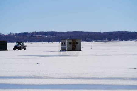 Téléchargez les photos : Green Lake, Wisconsin États-Unis - 11 février 2023 : Des gens pêchent sur la glace sur un lac gelé dans des cabanes à glace. - en image libre de droit