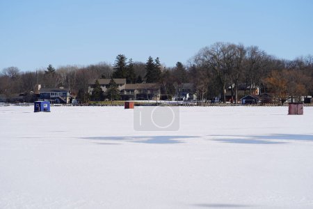 Téléchargez les photos : Green Lake, Wisconsin États-Unis - 11 février 2023 : Des gens pêchent sur la glace sur un lac gelé dans des cabanes à glace. - en image libre de droit