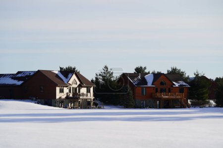 Photo for New Lisbon, Wisconsin USA - February 25th, 2023: Wooden cabin houses in the Winter season. - Royalty Free Image