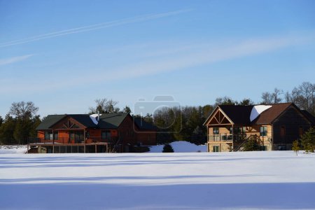 Photo for New Lisbon, Wisconsin USA - February 25th, 2023: Wooden cabin houses in the Winter season. - Royalty Free Image