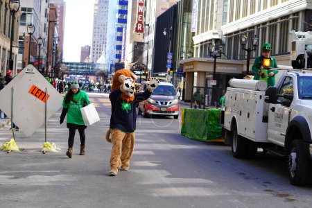 Téléchargez les photos : Milwaukee, Wisconsin États-Unis - 12 mars 2022 : Une personne vêtue d'un costume de lion se promène et interagit avec les spectateurs du défilé de la Saint-Patrick. - en image libre de droit