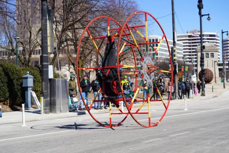 Téléchargez les photos : Milwaukee, Wisconsin États-Unis - 12 mars 2022 : Afro-américain fait de la gymnastique avec sa roue allemande au défilé de la Saint-Patrick. - en image libre de droit