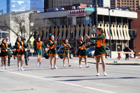 Photo for Milwaukee, Wisconsin USA - March 12th, 2022: Middle school girls danced around with batons in St. Patrick's Day parade. - Royalty Free Image