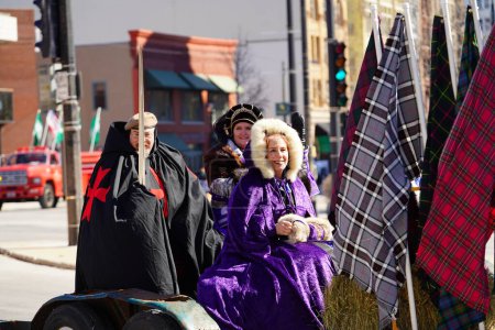 Téléchargez les photos : Milwaukee, Wisconsin États-Unis - 12 mars 2022 : Des hommes et des femmes vêtus de costumes médiévaux irlandais et portant des épées en marchant dans le défilé de la Saint-Patrick. - en image libre de droit