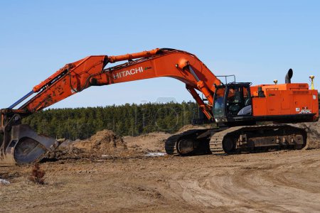 Foto de Nueva Lisboa, Wisconsin, EE.UU. - 19 de marzo de 2023: Excavadora naranja Hitachi 870 sin usar situada en un sitio de excavación. - Imagen libre de derechos