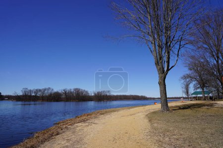 Foto de Camino de la suciedad a lo largo de un lago a principios de primavera. - Imagen libre de derechos