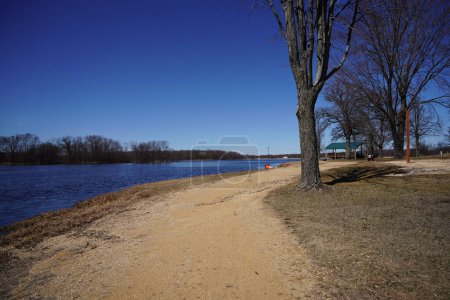 Foto de Camino de la suciedad a lo largo de un lago a principios de primavera. - Imagen libre de derechos