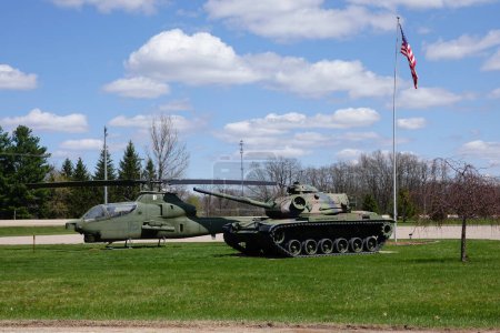 Téléchargez les photos : New Lisbon, Wisconsin États-Unis - 2 mai 2023 : Réplique de char de l'armée militaire M60A1 et hélicoptère Bell AH-1 Cobra Attack des États-Unis assis sur un site commémoratif des anciens combattants. - en image libre de droit