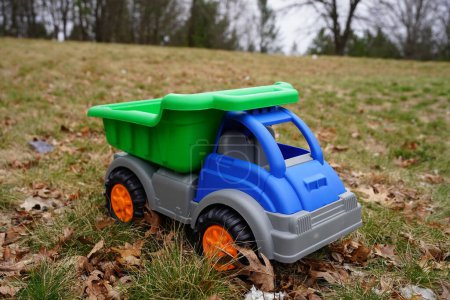 Téléchargez les photos : Camion à benne jouet bleu de l'enfant se trouve à l'extérieur au début du printemps. - en image libre de droit