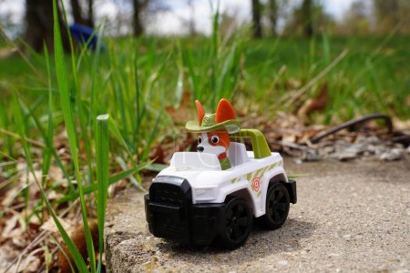 Foto de Nueva Lisboa, Wisconsin, EE.UU. - 10 de mayo de 2023: Figura de acción del juguete de la patrulla de patas Rastreador sentado afuera alrededor de la hierba. - Imagen libre de derechos