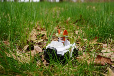 Foto de Nueva Lisboa, Wisconsin, EE.UU. - 10 de mayo de 2023: Figura de acción del juguete de la patrulla de patas Rastreador sentado afuera alrededor de la hierba. - Imagen libre de derechos