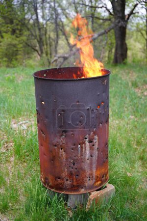 Téléchargez les photos : Brûler le tonneau de déchets se trouve à l'extérieur pendant l'été. - en image libre de droit