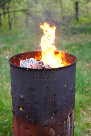 Foto de El barril de basura en llamas se sienta afuera durante el verano. - Imagen libre de derechos