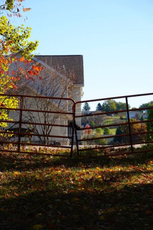 Téléchargez les photos : La vieille barrière enchaînée rouillée se dresse devant un sentier de passage naturel pendant la saison automnale d'automne. - en image libre de droit