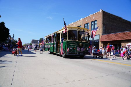 Photo for Sheboygan, Wisconsin / USA - July 4th, 2019: Titletown trolley bus travel through 4th of july american freedom pride parade - Royalty Free Image