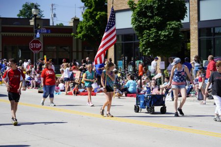 Foto de Sheboygan, Wisconsin, EE.UU. - 4 de julio de 2019: Belén luterana iglesia y escuela adultos y niños miembros vestidos con colores de orgullo de la libertad estadounidense repartiendo dulces a los espectadores en desfile - Imagen libre de derechos