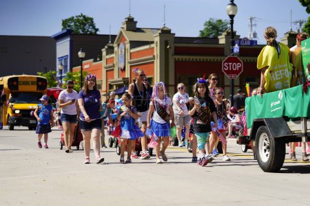 Foto de Sheboygan, Wisconsin, EE.UU. - 4 de julio de 2019: Belén luterana iglesia y escuela adultos y niños miembros vestidos con colores de orgullo de la libertad estadounidense repartiendo dulces a los espectadores en desfile - Imagen libre de derechos