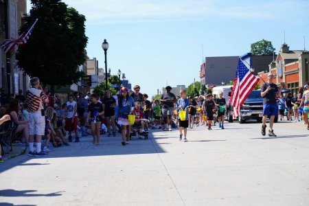 Foto de Sheboygan, Wisconsin - 4 de julio de 2022: Los participantes del desfile del Freedom Fest repartieron dulces a los espectadores adultos y niños. - Imagen libre de derechos