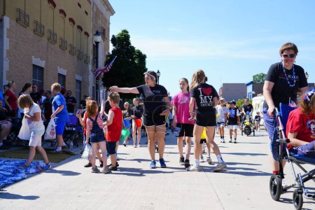 Foto de Sheboygan, Wisconsin - 4 de julio de 2022: Los participantes del desfile del Freedom Fest repartieron dulces a los espectadores adultos y niños. - Imagen libre de derechos