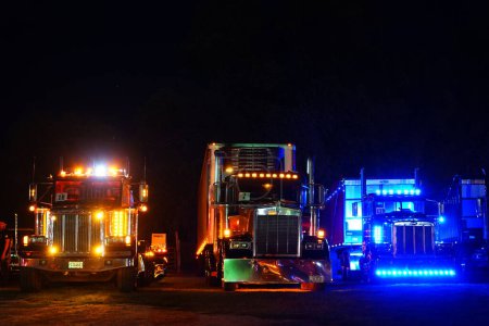 Photo for Waupun, Wisconsin USA - August 11th, 2023: Big rig trucks and Semi trucks glowed during the night with their yellow caution lights on. - Royalty Free Image