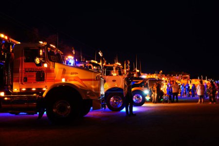 Photo for Waupun, Wisconsin USA - August 11th, 2023: Big rig trucks and Semi trucks glowed during the night with their yellow caution lights on. - Royalty Free Image