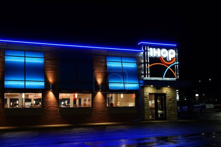 Téléchargez les photos : Fond du Lac, Wisconsin États-Unis - 11 août 2023 : Le restaurant de petit déjeuner IHOP International House of Pancakes brille de bleu fluo pendant la nuit. - en image libre de droit
