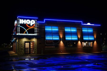 Foto de Fond du Lac, Wisconsin Estados Unidos - 11 de agosto de 2023: IHOP International House of Pancakes desayuno restaurante brilla de color azul neón durante la noche. - Imagen libre de derechos