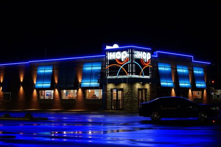 Photo for Fond du Lac, Wisconsin USA - August 11th, 2023: IHOP International House of Pancakes breakfast restaurant glows neon blue during the night. - Royalty Free Image