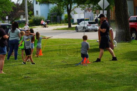 Photo for Fond du Lac, Wisconsin USA - August 1st, 2023: Local Police, sheriff and firefighter officers gathered together with community families for the National Night Out family fun event - Royalty Free Image
