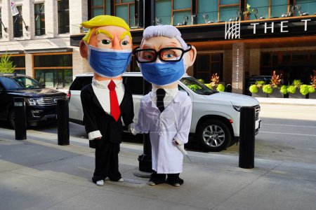 Foto de Milwaukee, Wisconsin, Estados Unidos - 23 de agosto de 2023: Dos personas vestidas con disfraces de Donald Trump y Anthony Fauci enmascarados en el Foro Fiserv durante el debate presidencial republicano de 2024. - Imagen libre de derechos