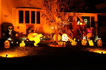 Téléchargez les photos : New Lisbon, Wisconsin États-Unis - 30 octobre 2021 : Les décorations d'Halloween illuminent la cour du propriétaire de la maison la nuit. - en image libre de droit