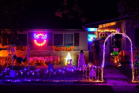 Foto de Nueva Lisboa, Wisconsin, EE.UU. - 30 de octubre de 2021: Las decoraciones de Halloween brillan por la noche en el patio del propietario de la casa. - Imagen libre de derechos