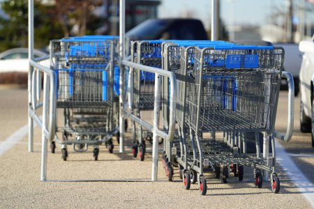 Photo for Fond du Lac, Wisconsin USA - November 26th, 2022: Blue and grey shopping carts sitting at a cart corral at Walmart parking lot. - Royalty Free Image