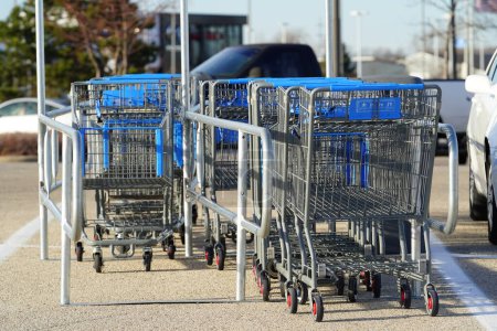 Téléchargez les photos : Fond du Lac, Wisconsin États-Unis - 26 novembre 2022 : Chariots bleus et gris assis sur un corral de chariots au stationnement Walmart. - en image libre de droit